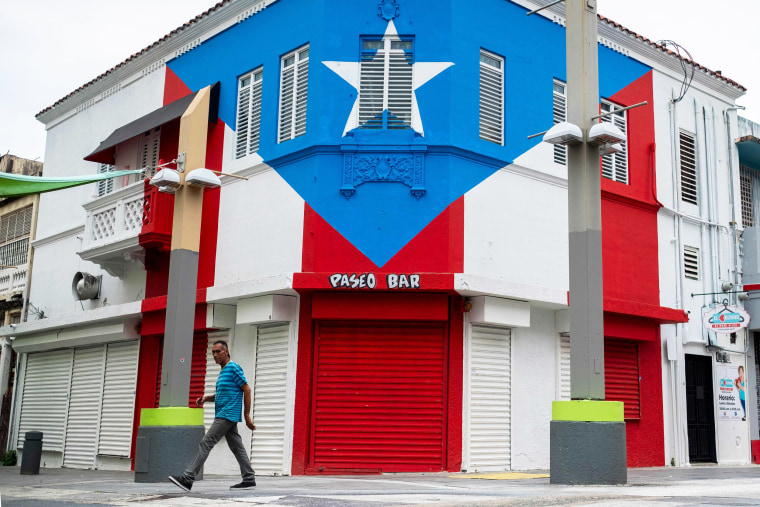 A man walks through a closed commercial area in San Juan on March 25, 2020.