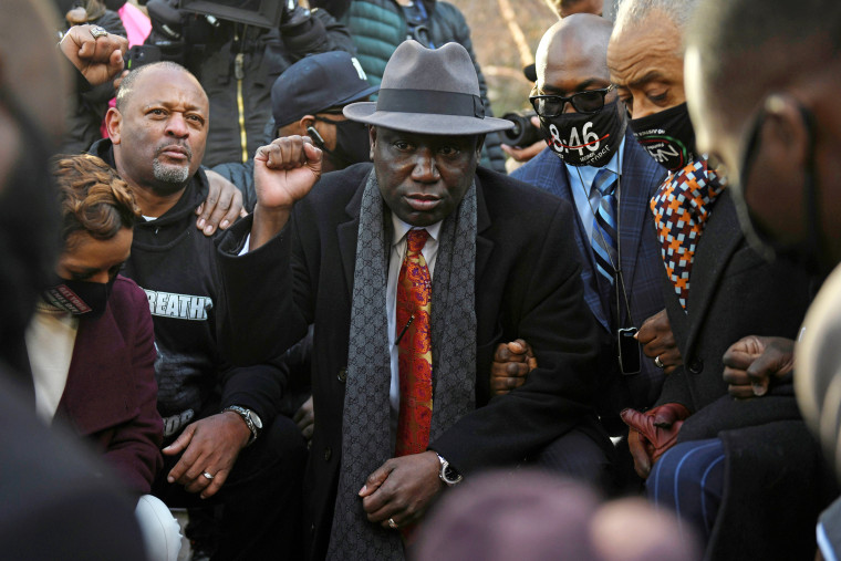 Floyd family attorney Ben Crump kneels alongside Rev. Al Sharpton and the Floyd family, for 8 minutes and 46 seconds, following a news conference outside the Hennepin County Government Center in Minneapolis on March 29, 2021.