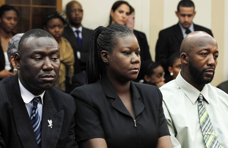 Tracy Martin, right, and Sybrina Fulton, Trayvon Martin's parents, sit with their lawyer Benjamin Crump at a public forum on Trayvon's death on Capitol Hill on March 27, 2012.
