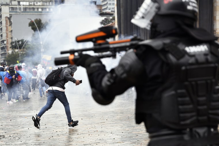 A riot police officer shoots towards protesters at Bolivar Square during a national strike on May 05, 2021 in Bogota, Colombia.