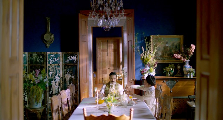 Ignacio de la Torre y Mier sits by his wife Amada, played by Mabel Cadena, at the dining room table.