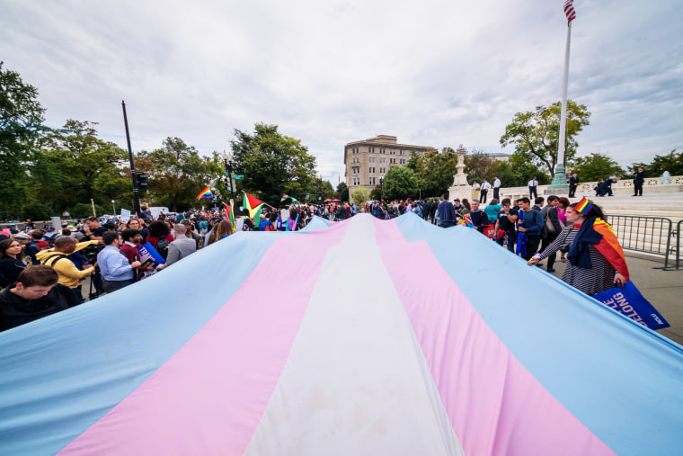 Protesters unfurl a giant transgender pride flag outside the Supreme Court in Washington on Oct. 8, 2019.