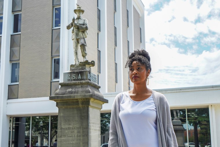 Camille Bennett poses for a photo in front of the confederate statue that she is trying to have moved to the confederate cemetery in Florence, Ala., on May 19, 2021.