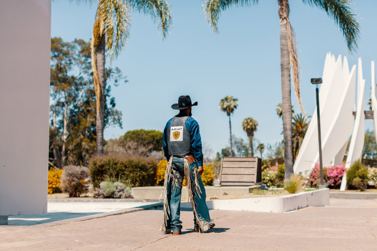 Image of Tre Hosley in his cowboy uniform walking away.
