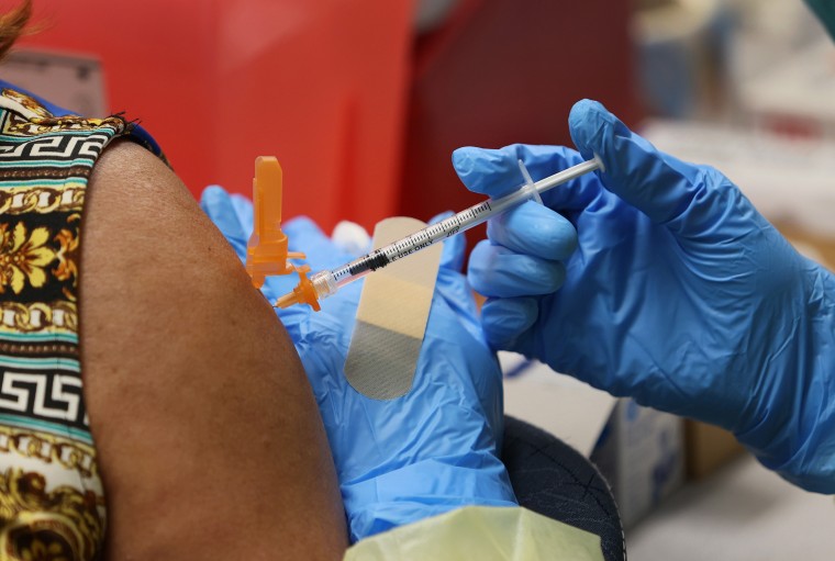 A health worker administers a Pfizer Covid-19 vaccination to a woman at Miami International Airport in Miami on May 10, 2021.