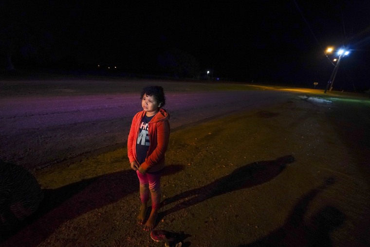 Emely, 8, of Honduras, stands alone after turning herself in upon crossing the U.S.-Mexico border on May 13, 2021, in La Joya, Texas. The unaccompanied child cried as she told her story of losing her guides and walking for miles with another group along the muddy paths of the Rio Grande Valley after a storm. She had lost track of a man who had the number of her parents in the U.S. and did not know how to get in touch with any of her relatives. 