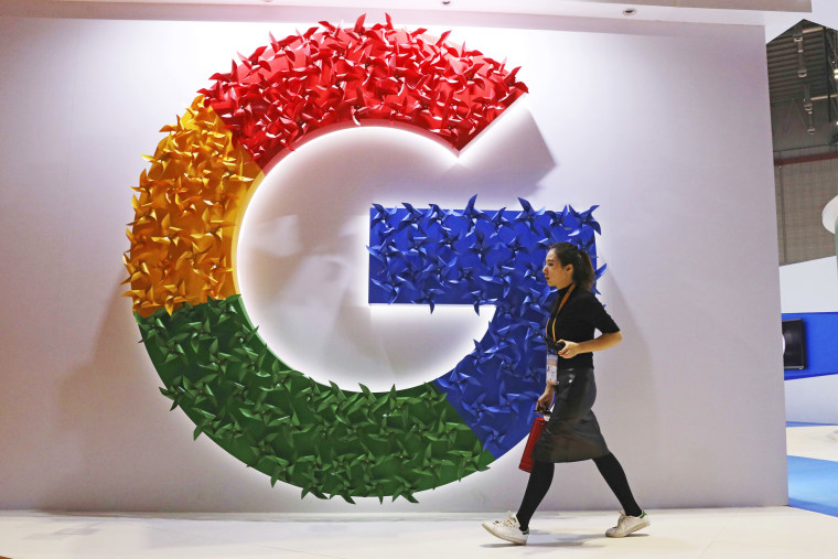 A woman walks past the logo for Google at the China International Import Expo in Shanghai on November 5, 2018.