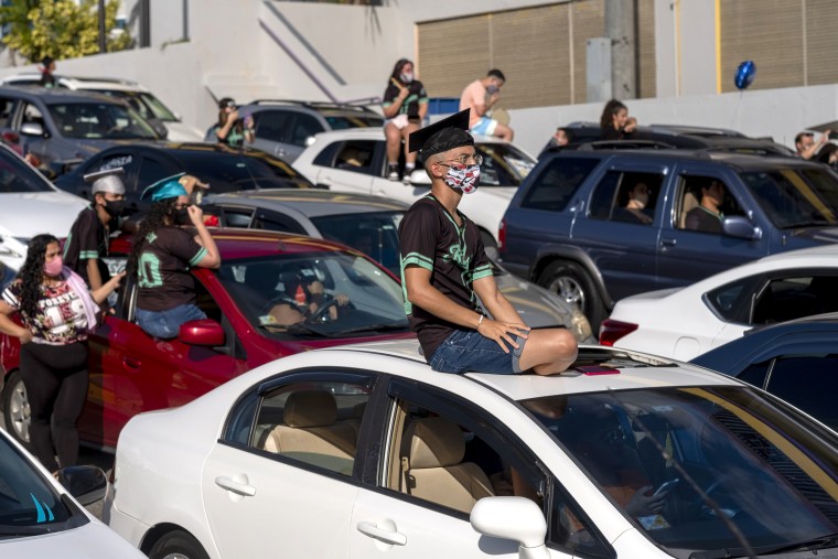 A graduating student from the Ramon Power Y Giralt High School attends a symbolic graduation from his car to maintain social distance at a parking lot in Las Piedras, Puerto Rico, on May 13, 2020.