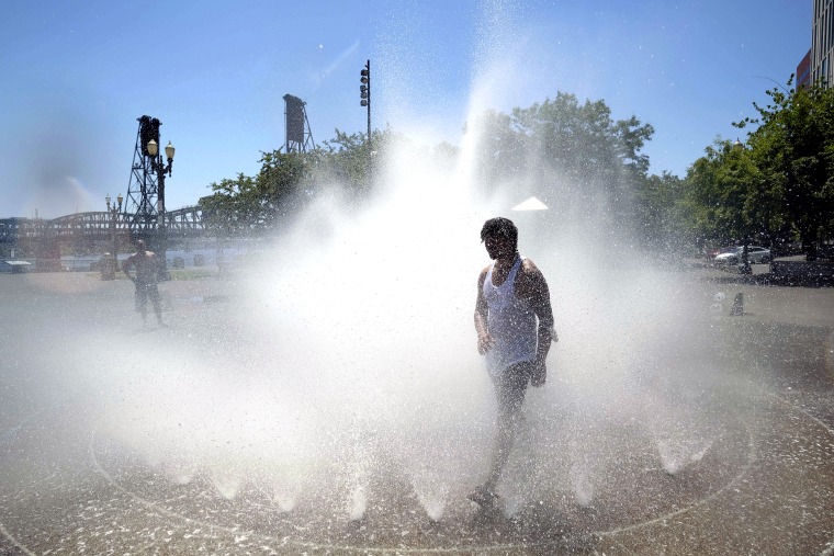 Harrison Valetski cools off in Salmon Street Springs in downtown Portland, Ore., on Monday, where temperatures reached an all-time high of 116 degrees Fahrenheit.