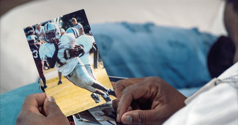 A family member views photo of Kendrick as a youth football player. 