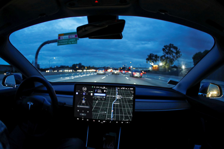 Image: A Model 3 Tesla vehicle navigates morning rush hour using the car's auto pilot feature in Los Angeles