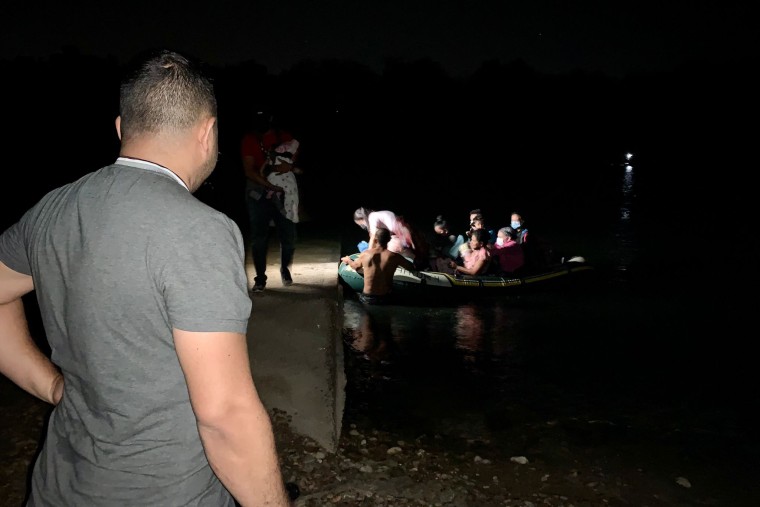 Edín Galeano watches migrants cross the Rio Grande on a raft while waiting to find his family.