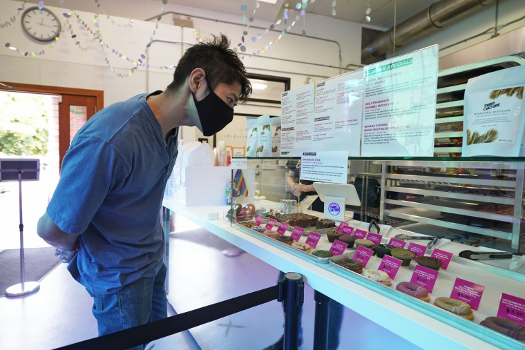 A man looks over a display case filled with mochi donuts and muffins at the Third Culture Bakery in Berkeley, Calif., on Aug. 19, 2021.