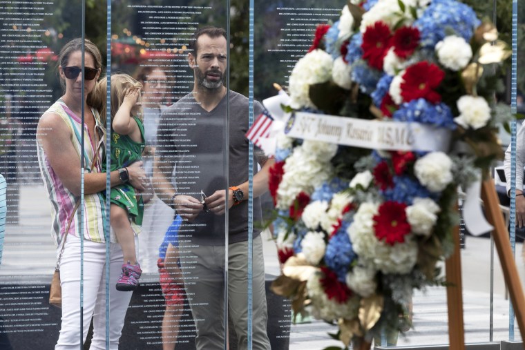 Retired Army Capt. Stephen Hunnewell stands with his family behind a wreath in memory of Marine Sgt. Johanny Rosario Pichardo following a ceremony at the Massachusetts Fallen Heroes Memorial on Aug. 28, 2021, in Boston.