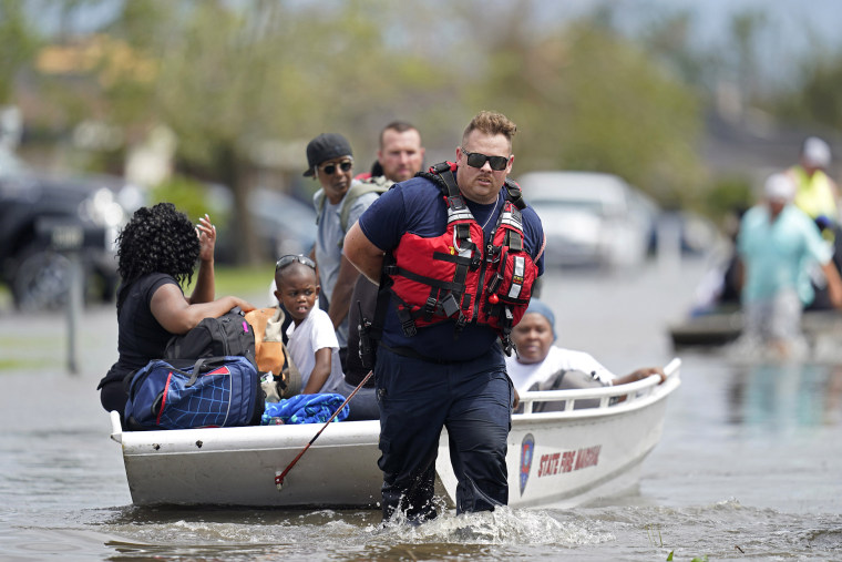 Members of the Louisiana State Fire Marshal's office rescue people from floodwaters in the aftermath of Hurricane Ida in New Orleans, La., Monday, Aug. 30, 2021. 