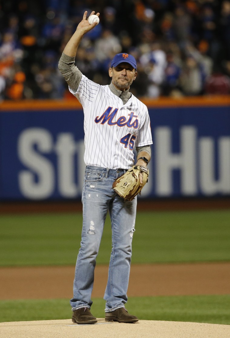 Tim McGraw holds up a baseball
