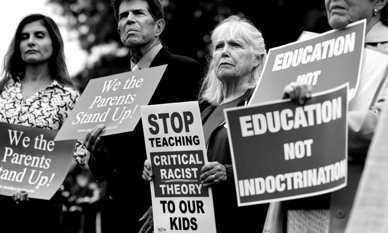 Image: Protestors holding signs that read,"We the Parents Stand Up!", Stop teaching critical racist theory to our kids" and "Education not indoctrination".