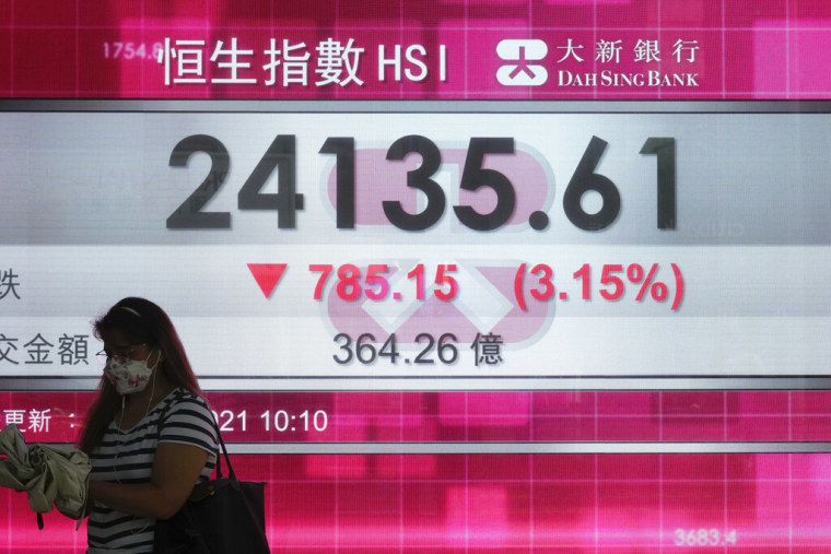 Una mujer pasa enfrente de una pantalla que muestra los índices de valores de la Bolsa de Hong Kong, el 20 de septiembre de 2021.