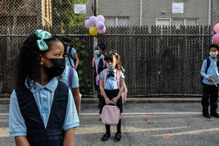 Los estudiantes esperan en la fila para ingresar a una escuela pública en las primeras clases en el distrito del Bronx en Nueva York, el lunes 13 de septiembre de 2021.