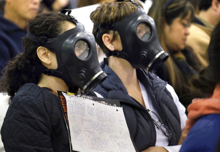 Manifestantes con máscaras de gas asisten a una audiencia el 16 de enero de 2016 sobre la mayor fuga de metano conocida en Estados Unidos.