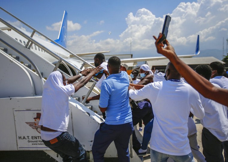 Un grupo de haitianos deportados de Estados Unidos tratan de subir al avión en el que viajaron a Haiti, en el Aeropuerto Toussaint Louverture, en Puerto Príncipe, el martes 21 de septiembre de 2021. 