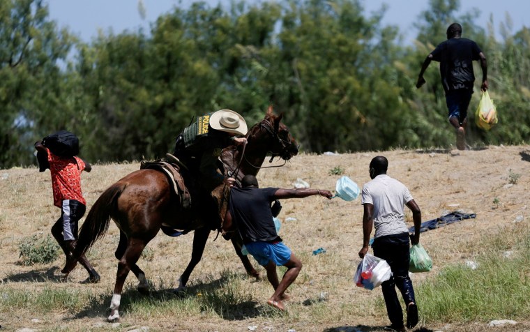 Un agente de la patrulla fronteriza estadounidense a caballo agarra la camisa de un migrante que intenta regresar a Estados Unidos a lo largo del Río Grande el 19 de septiembre.