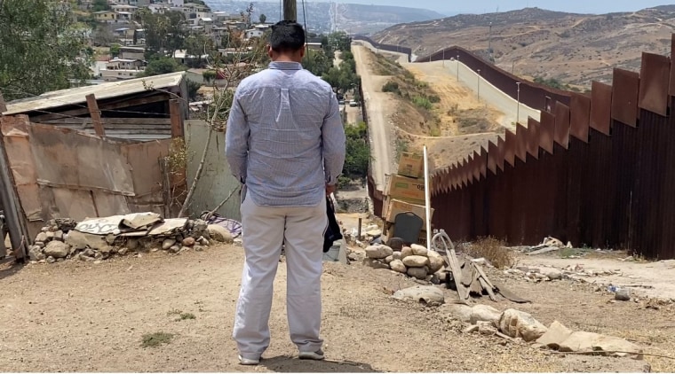 Un hombre de espaldas junto al muro fronterizo. Es Daniel, quien fue secuestrado, ahora espera una resolución de una solicitud de asilo en EE.UU. desde Tamaulipas, México.