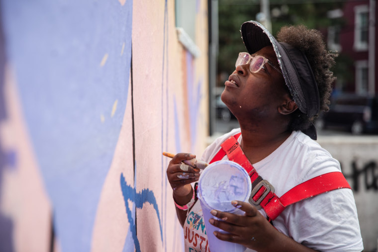 A painter works on the We Are Universal mural on Sept. 8, 2021 in Philadelphia.