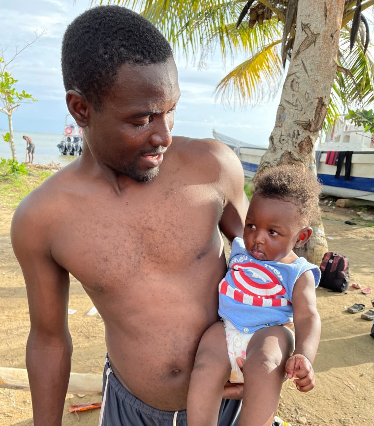 Fritz Nor holds his 6-month-old son King born while he worked as a construction worker in Brazil.  He wants to move to the US to give his son a better life, he said.
