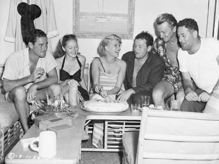 Image: Rita Hayworth cuts her birthday cake during an intimate party aboard Errol Flynn's yacht, "Zaca,". on Nov. 19, 1946 in Acapulco, Mexico. Wither her from left, Errol Flynn and his wife Nora and her husband, Orson Welles.