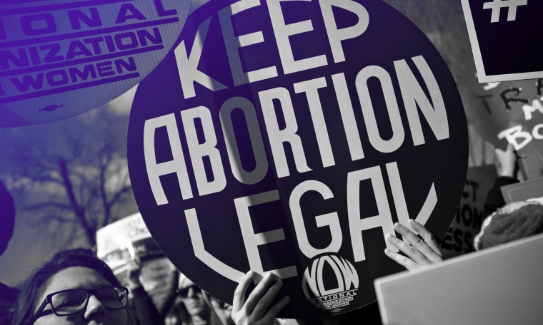 Image: Protestor holding up a sign that reads,"Keep abortion legal".