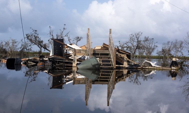 Image: A destroyed home in floodwater.