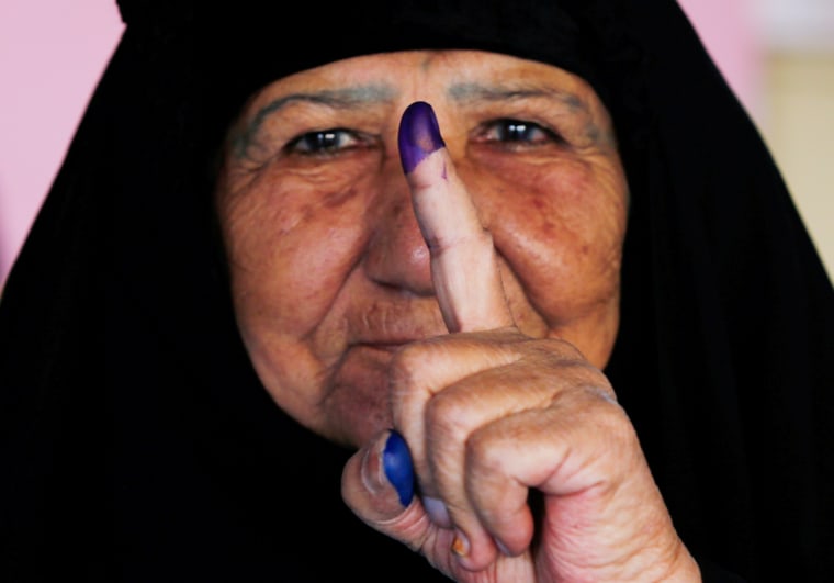 Image: An Iraqi woman shows her ink-stained finger after casting her vote at a polling station during the parliamentary election in the Sadr city