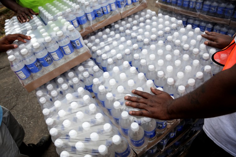 Image: Workers wait to hand out water bottles to Flint residents in Michigan in 2016.