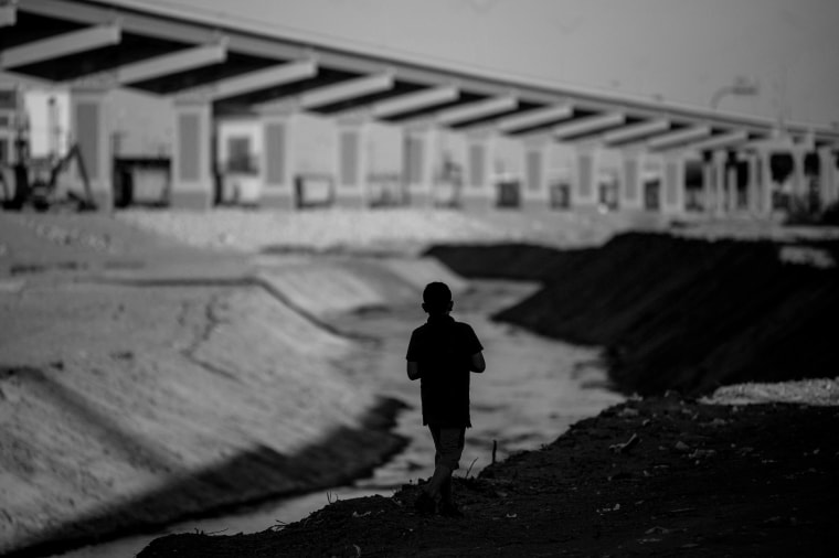 Image: A boy walks along the Rio Bravo in Ciudad Juarez on the Mexican side of the border with Texas on March 22, 2021.