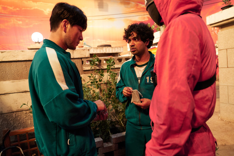 Image: Ali Abdul, played by Tripathi Anupam, center , speaks with Sangwoo played by Park Hae-soo, left, in "Squid Game."