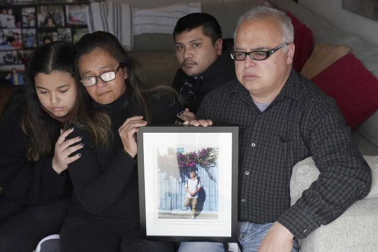 Maria Cassandra Quinto-Collins, second  left, holds a photo of her son, Angelo Quinto, while sitting with daughter Bella Collins, son Andrei Quinto and husband Robert Collins during an interview in Antioch, Calif., on March 16.