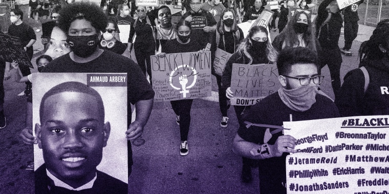 Image: People marching with a portrait of Ahmaud Arbery and  other signs that read,"Black Lives Matter".