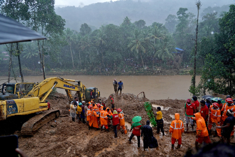 Image: Rescue workers carry the body of a victim after recovering it from the debris of a residential house following a landslide in Kokkayar