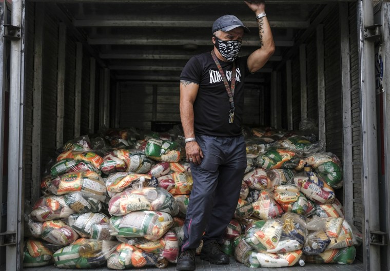 A man waits to unload bags of basic food staples, such as pasta, sugar, flour, and kitchen oil, provided residents through the CLAP government food assistance program in the Santa Rosalia neighborhood of Caracas, Venezuela on April 10, 2021.