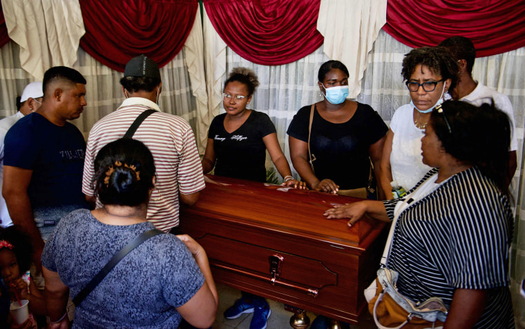 Image:  Relatives mourn next to Alex Quiñonez' coffin at a funeral home in southern Guayaquil, Ecuador on Oct. 23, 2021.