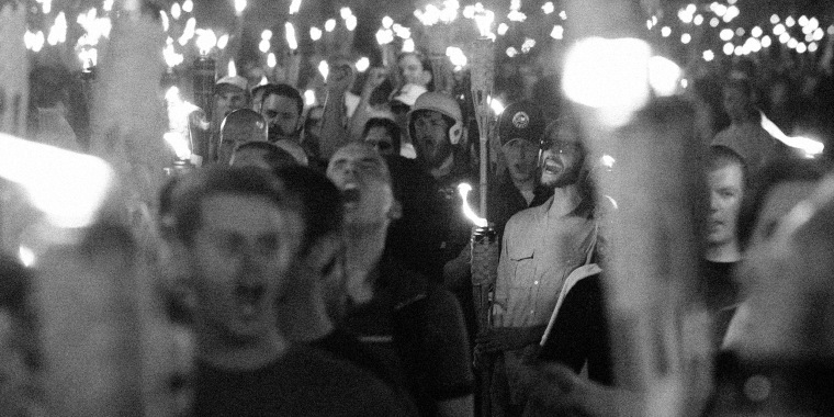 Image: People marching with tiki torches.