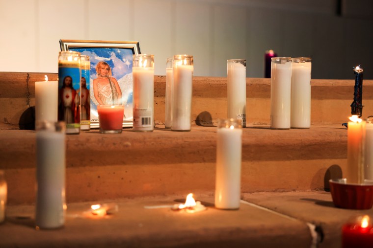 A photo of cinematographer Halyna Hutchins stands among candles at a vigil in Albuquerque, N.M., on Oct. 23, 2021.