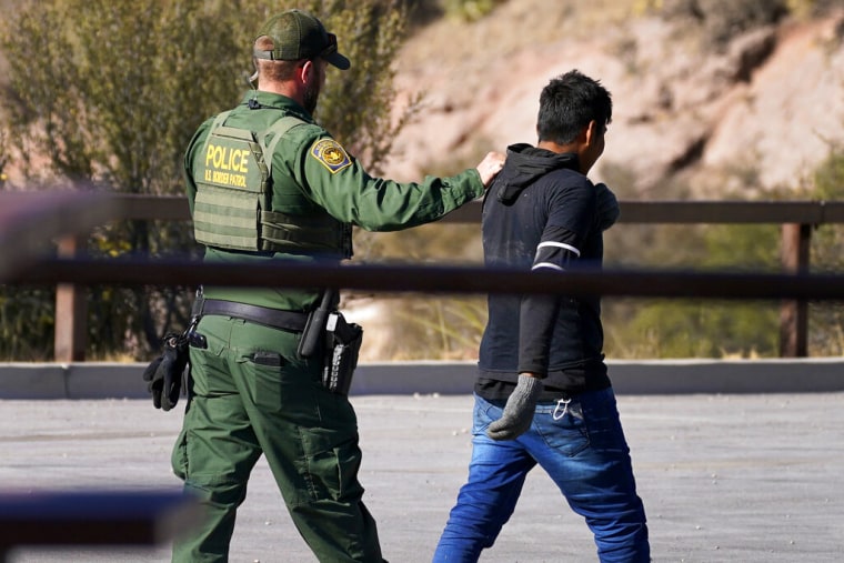 Un agente fronterizo camina detrás de un migrante interceptado en Arizona el 9 de diciembre de 2020.