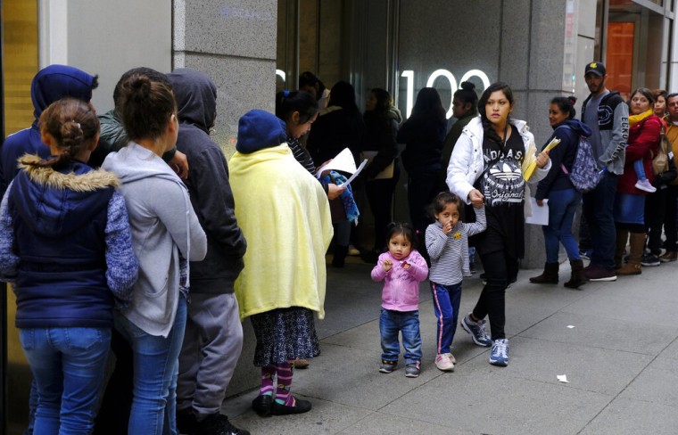 Cientos de personas hacen fila afuera de una oficina de inmigración en San Francisco.