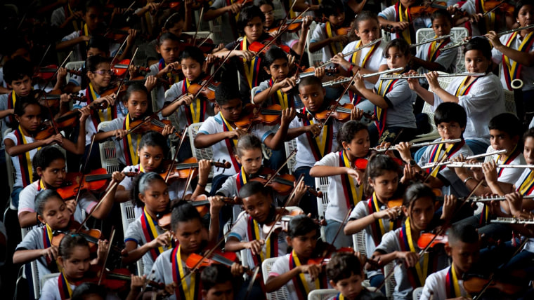 Músicos niños y adolescentes de instrumentos de viento y cuerdas tocan durante una presentación en 2012 de una de las orquestas juveniles que forma parte de El Sistema venezolano.