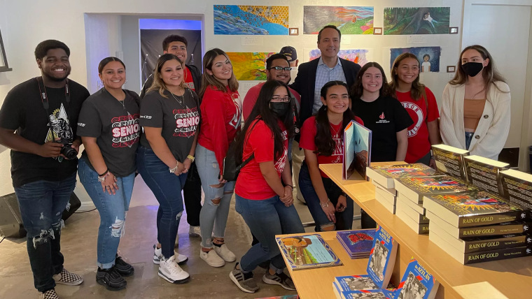 Once adolescentes de diferentes orígenes étnicos y raciales posan frente a libros en un estante al lado del senador estatal por Texas José Menéndez, para celebrar la inauguración de una nueva librería.