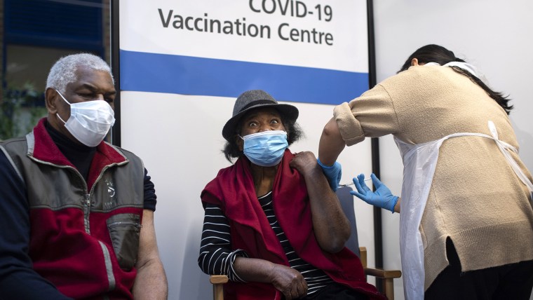 Lorna Lucas, de 81 años, recibe la vacuna Pfizer/BioNTech contra el COVID-19 poco antes de su esposo, Winston (izq) en el Guy's Hospital, Londres, el 8 de diciembre de 2020.