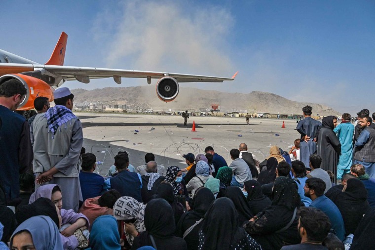 Afghans wait to leave the airport in Kabul on Aug. 16, 2021.