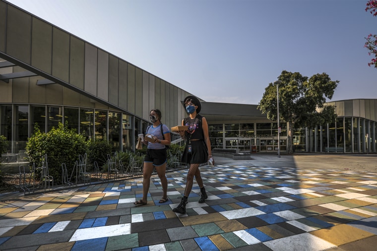 Students walk back to their dorms with takeout breakfast from Gastronome at Cal State University of Fullerton on Aug. 21, 2020 in Fullerton, Calif.